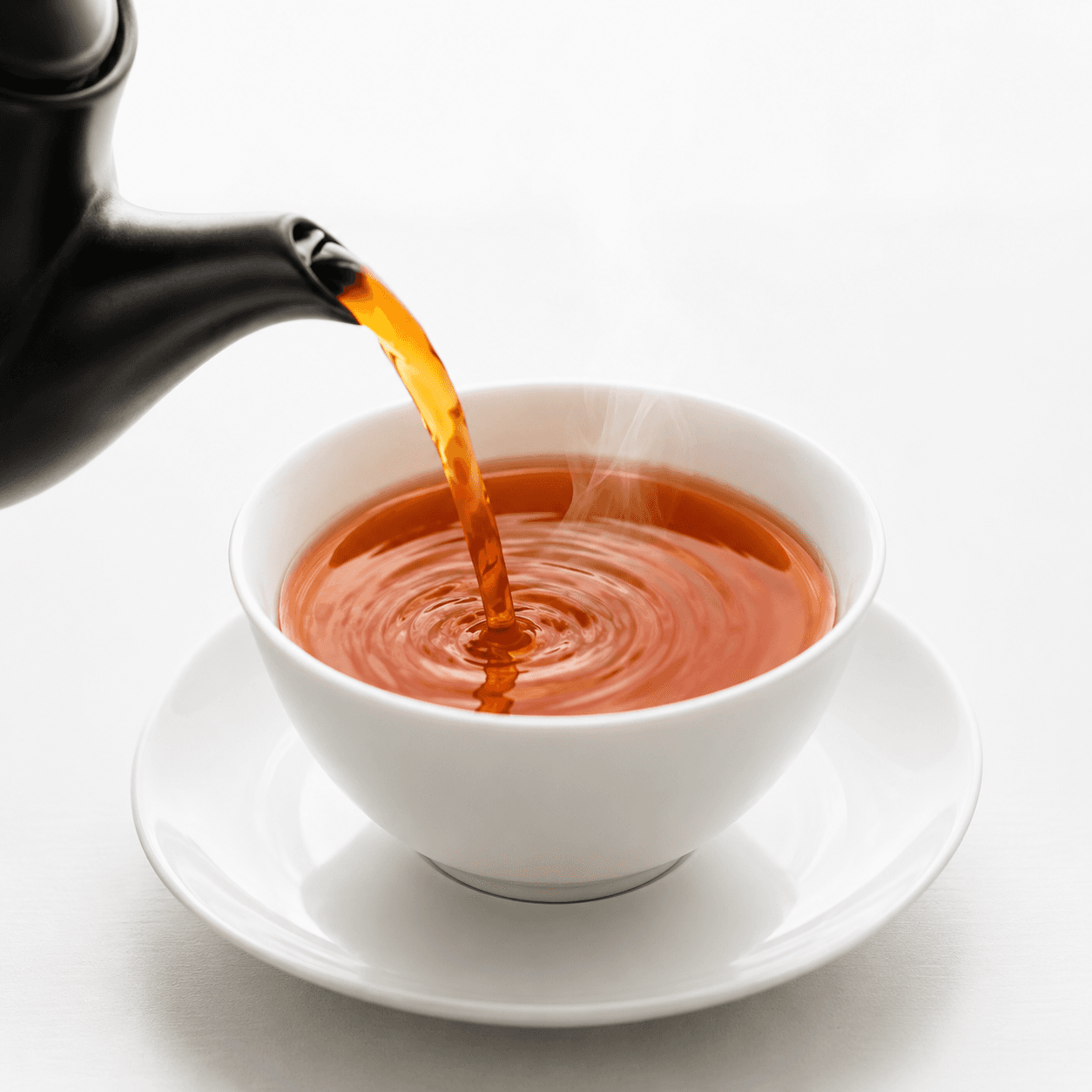 Golden tea being poured from a rustic ceramic teapot